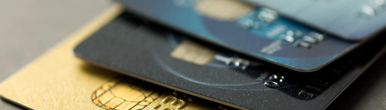 A close-up shot of four credit cards stacked on top of each other slightly fanned out. 
